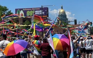 Denver Pride parade marchers approach the Colorado capitol.